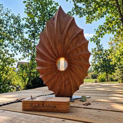 Filo di Luce, scultura in cedro del Libano con selenite illuminata e scatola di comando RadiAnima, fotografata nella natura.